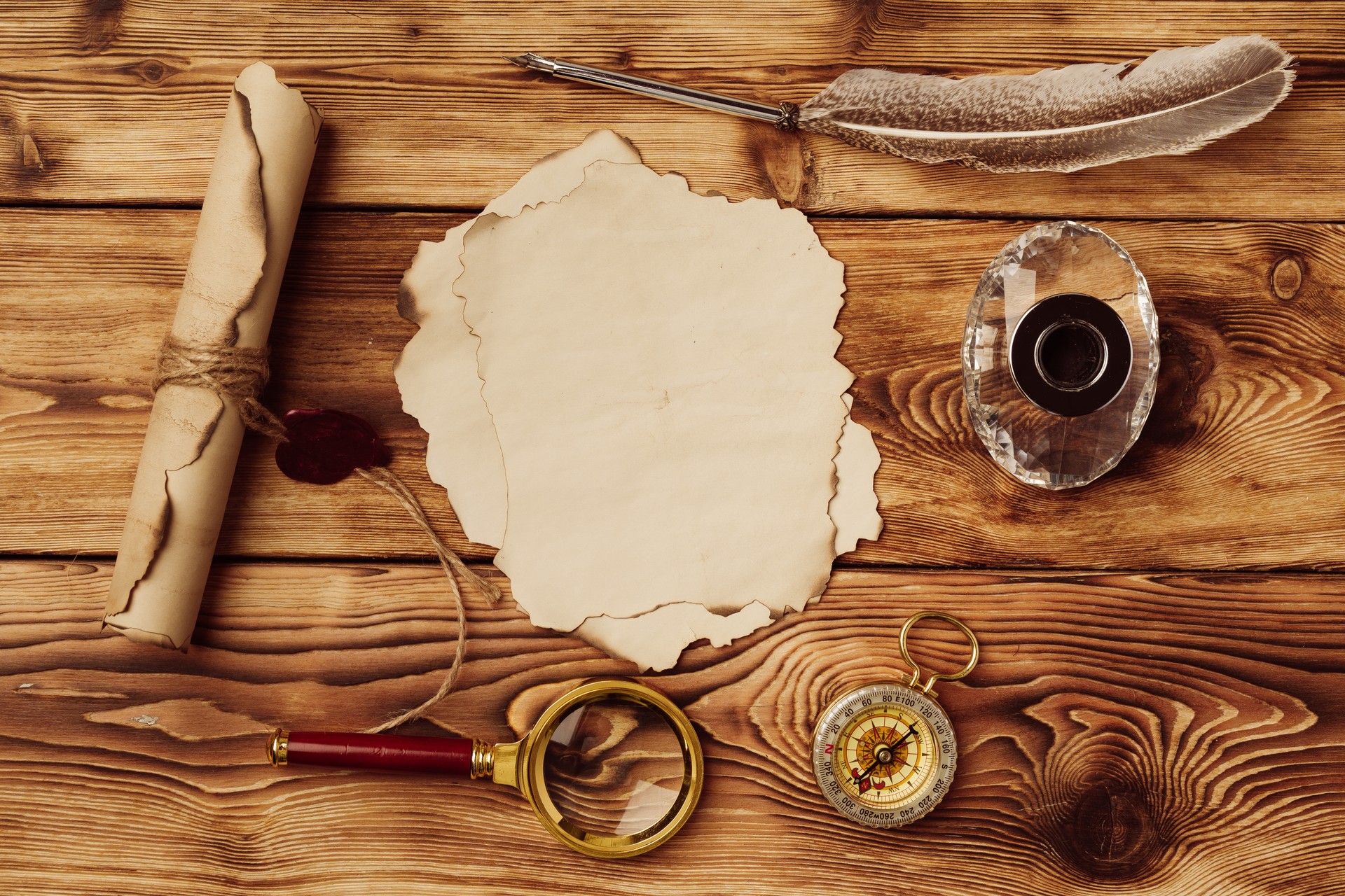 Old paper on brown wood background with feather